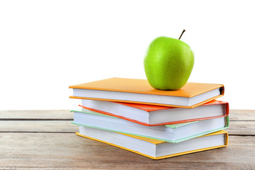 Few books with green apple on table