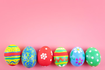 Multicoloured Easter eggs on pink background, top view