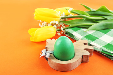 Easter eggs and tulips on napkin, orange background