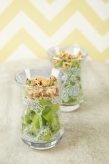 Chia seeds pudding with kiwi and cookies on striped background