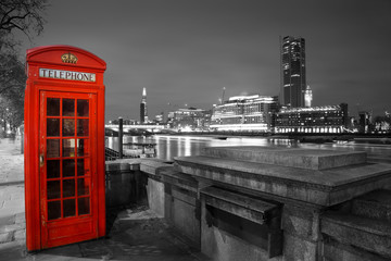 Fototapeta na wymiar Rote Telefonzelle an der Themse in London bei Nacht
