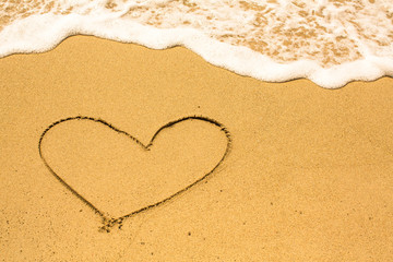Heart drawn on the sand of a sea beach.