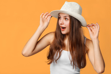 Surprised happy woman looking sideways in excitement. Isolated on orange background