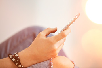 Closeup image of a teenager is searching information in network on mobile phone during free time....