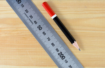  pencil and  stainless ruler on wooden table