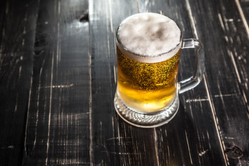 Mug of beer, on a wooden background