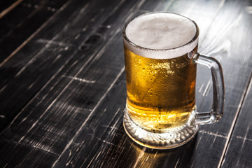 Mug of beer, on a wooden background