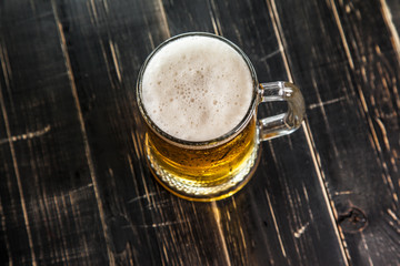 Mug of beer, on a wooden background