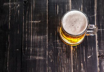 Mug of beer, on a wooden background