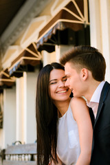 Couple kissing happiness fun. Interracial young couple embracing laughing on date.