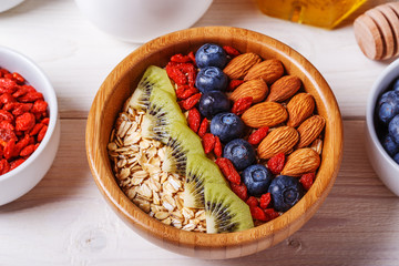 Healthy breakfast - bowl of oat flakes with fresh fruit, almond