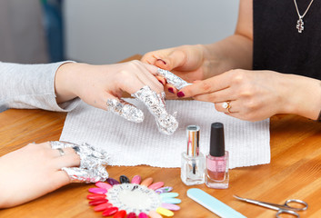Manicure process: nails wrapped in foil