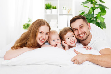 Fototapeta premium happy family at home in the bed