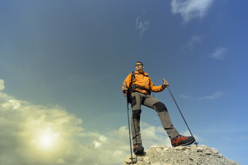 Young man with backpack on a mountain top on a sunny day.