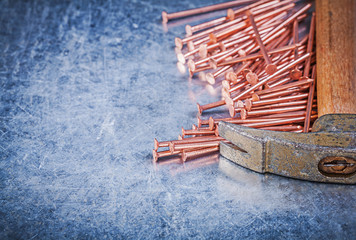 Vintage claw hammer copper construction nails on metallic backgr