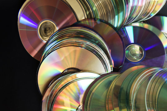 CDS y DVD esparcidos sobre fondo negro
