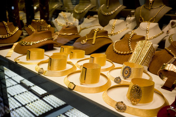 Golden items in the display window of a jewelery store, gold market