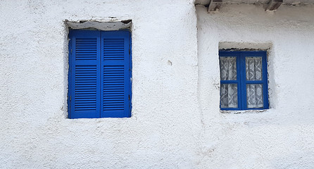 Fototapeta na wymiar Blue window on old white house in Greece