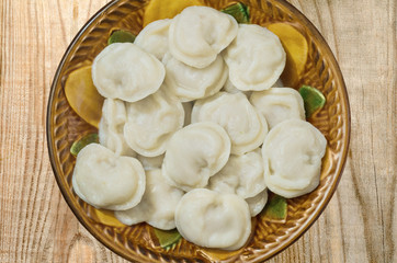 Ceramic bowl of boiled dumplings is on the boards