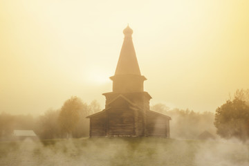 Ancient Church of the Assumption in the fog. Museum of wooden architecture Vitoslavitsy. Veliky...
