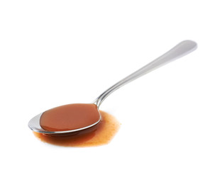 Steel spoon in a puddle of hot sauce