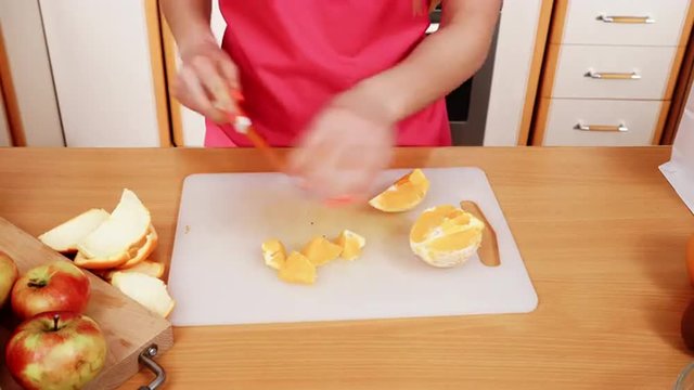 Woman housewife in kitchen cutting orange fruits 4K