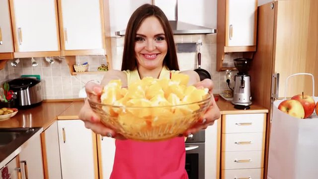 Woman holds bowl full of sliced orange fruits 4K