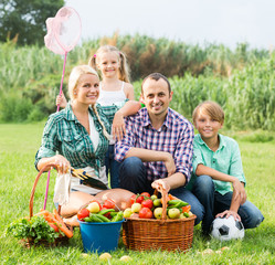 Family of four resting at countryside.