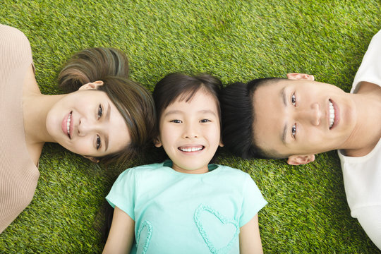top view of Happy  Young  Family lying on the grass