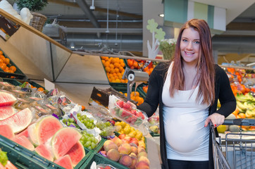 pregnant women choice strawberry in supermarket