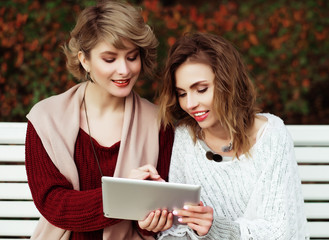beautiful women girls autumn using tablet outdoor