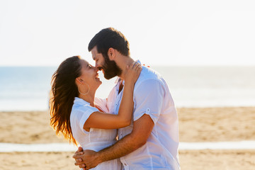 Happy newlywed family on honeymoon holidays - just married loving man and woman embracing  on sea sand beach. Travel lifestyle and people outdoor activity on summer vacation on tropical island.