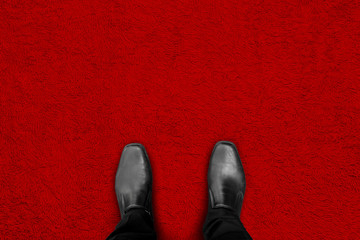Black shoes standing on red carpet