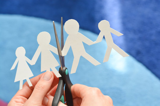 Family divorce concept with human paper shapes and scissors suggesting relationship problems