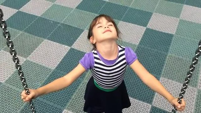 Slow motion of happy girl play on a net swing. Children childhood concept