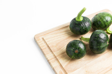 Young green pumpkin on wood support