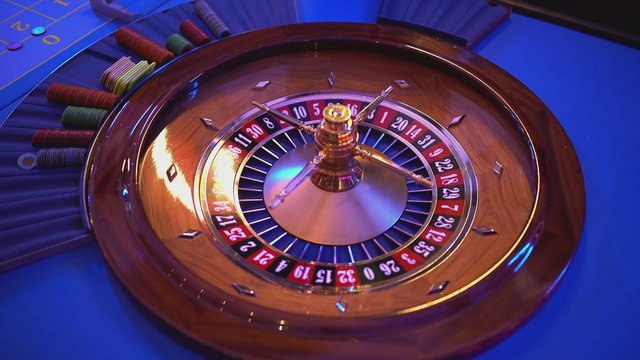 Roulette wheel - groupier spins the wheel - ball lands on field 14 red