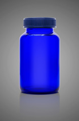 Blank blue glass bottle of supplement product isolated on gray b