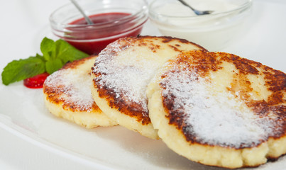 cheese pancakes with sour cream and strawberry sauce