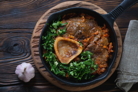 Above view of osso buco with gremolata in a frying pan, close-up