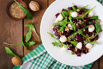 Salad of baked beets, arugula, cheese and nuts. Top view