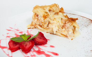 slice of decorated with strawberry napoleon cake, served on white plate