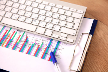 Office table with blank notepad and laptop 