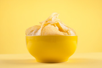 Potato chips in a bowl, isolated on background