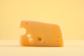 piece of cheese with holes on isolated background