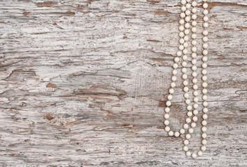 Vintage background with bead necklace on the old wood