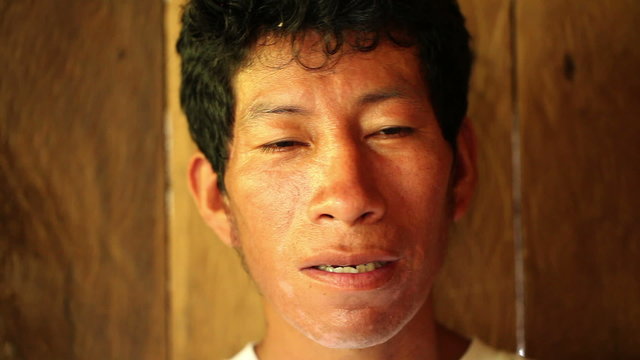 Amazonian farmer speaking in ancient Quechua,the most widely spoken indigenous language in the Americas with 8 10 million speakers. Shallow depth of field focuses on the face.