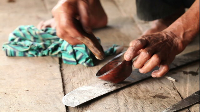 An adult woman creating pottery in a rural scene in the Ecuadorian Amazonia,showcasing the traditional finishing process.