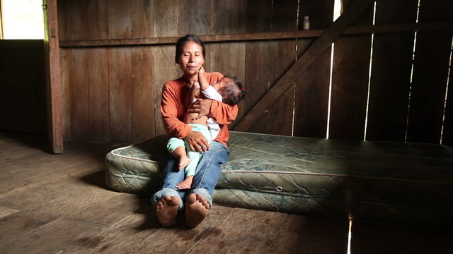 Mother and child living in extremely impoverished conditions in the Ecuadorian Amazonia,struggling for survival.