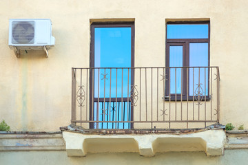 Balcony close-up on a background of the yellow walls of the hous